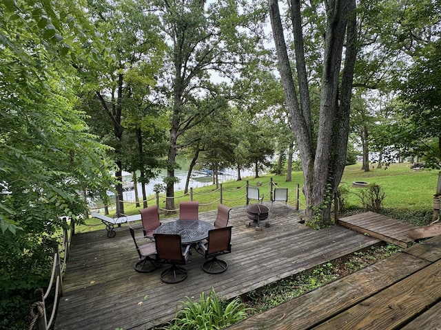 deck featuring a water view, a yard, and outdoor dining space