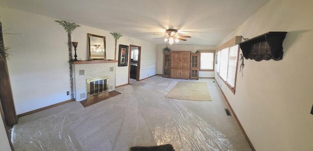 unfurnished living room featuring a ceiling fan, a fireplace, visible vents, and baseboards