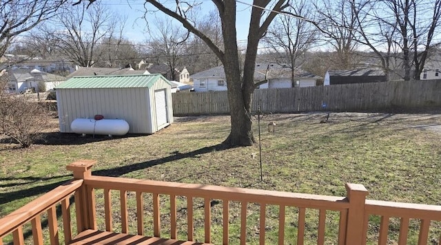 view of yard with a residential view, fence, a storage unit, and an outbuilding