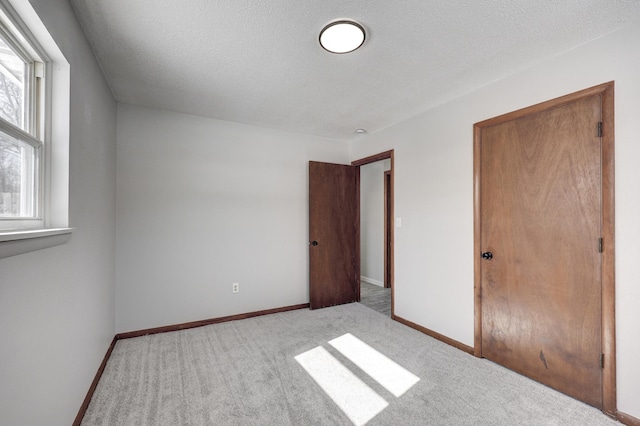 503 Chestnut St, Neosho, MO 64850 - unfurnished bedroom with baseboards, a textured ceiling, and light colored carpet