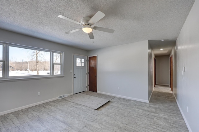 503 Chestnut St, Neosho, MO 64850 - foyer entrance featuring visible vents, ceiling fan, a textured ceiling, and baseboards