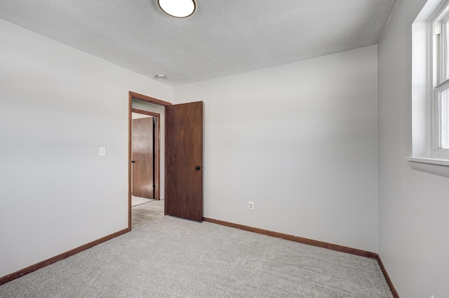 503 Chestnut St, Neosho, MO 64850 - spare room with light carpet, baseboards, and a textured ceiling