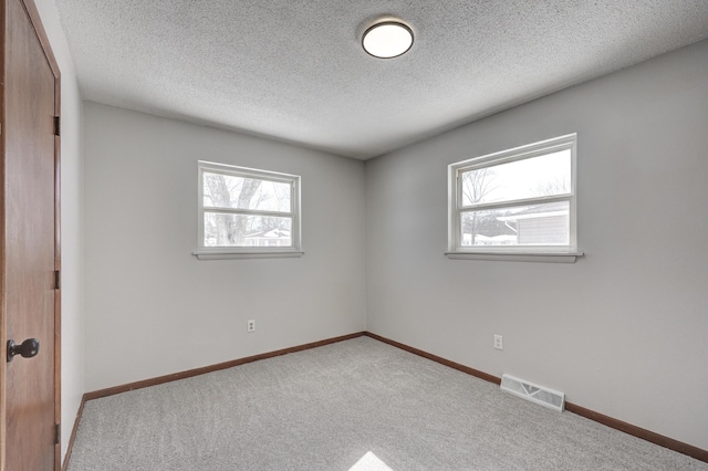 503 Chestnut St, Neosho, MO 64850 - empty room featuring baseboards, visible vents, a textured ceiling, and light colored carpet
