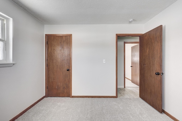 503 Chestnut St, Neosho, MO 64850 - unfurnished bedroom featuring light colored carpet, a textured ceiling, and baseboards