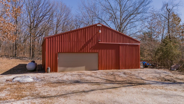 detached garage featuring dirt driveway