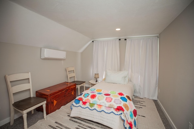 bedroom featuring a wall unit AC, carpet, baseboards, and vaulted ceiling