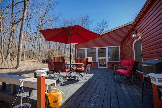 wooden terrace with outdoor dining space and area for grilling