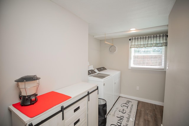 clothes washing area featuring laundry area, wood finished floors, washing machine and clothes dryer, and baseboards