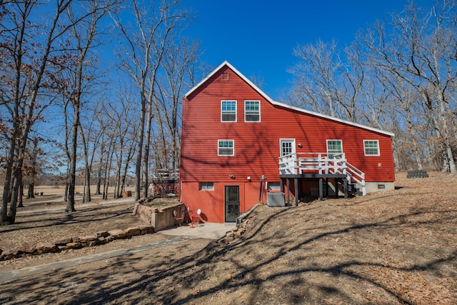 back of house with a deck, cooling unit, and a yard