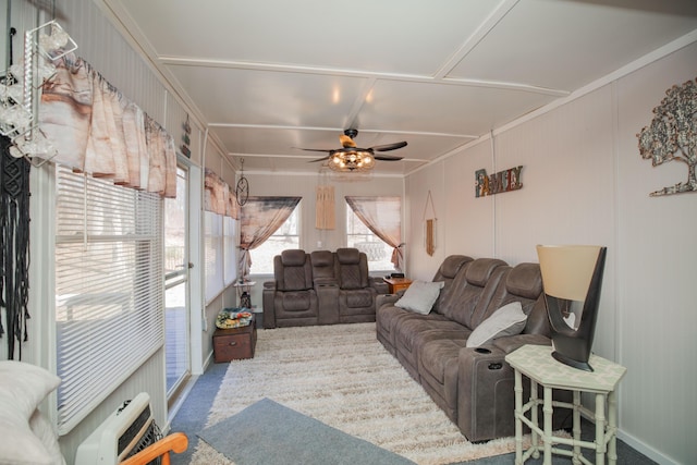 living room featuring carpet flooring, a ceiling fan, and heating unit