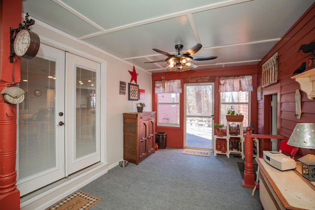 interior space with a ceiling fan, dark colored carpet, and french doors