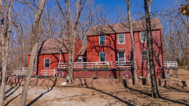 view of front of home with a shingled roof and a deck