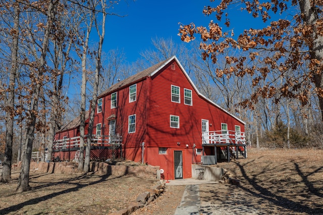 view of side of property with a deck and central AC unit