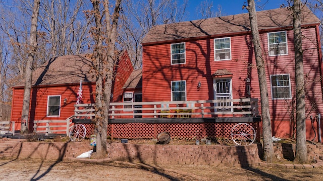 exterior space featuring roof with shingles and a wooden deck