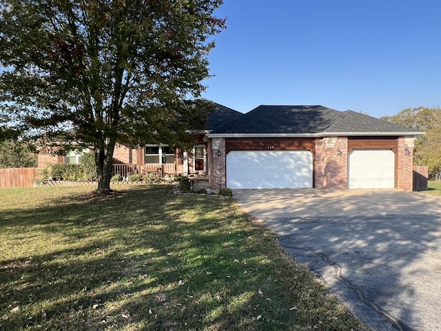 ranch-style house featuring covered porch, driveway, a front lawn, and an attached garage