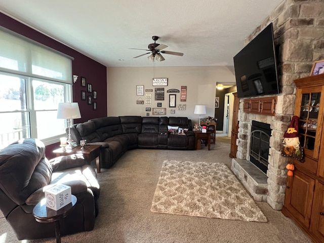 living area with light carpet, a fireplace, and ceiling fan