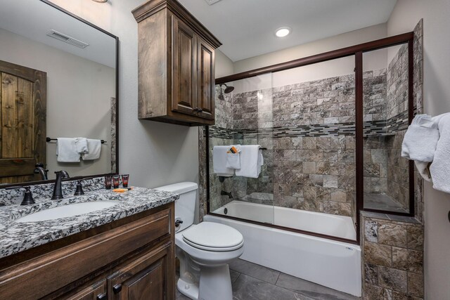 bathroom with visible vents, toilet, vanity, and shower / bath combination with glass door