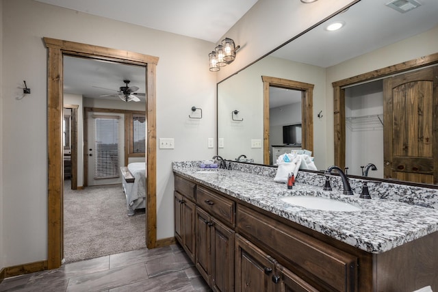 bathroom with a sink, double vanity, ceiling fan, and ensuite bathroom