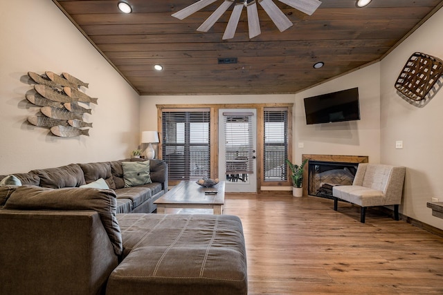 living area with a ceiling fan, a glass covered fireplace, wood finished floors, wooden ceiling, and lofted ceiling