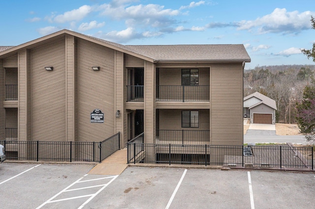 view of property with fence and uncovered parking