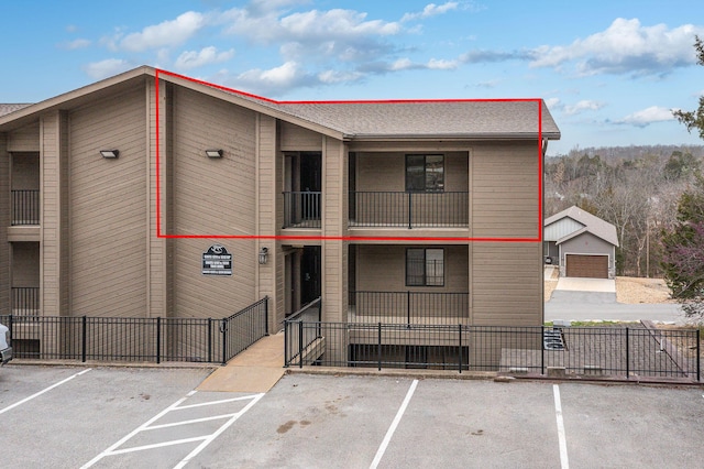 view of property featuring uncovered parking and fence
