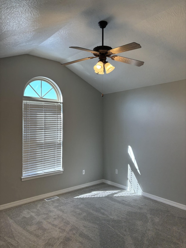 unfurnished room featuring carpet floors, a ceiling fan, visible vents, and a textured ceiling