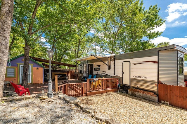 back of property featuring a deck and fence