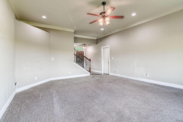 empty room featuring carpet floors, stairway, ornamental molding, a ceiling fan, and baseboards