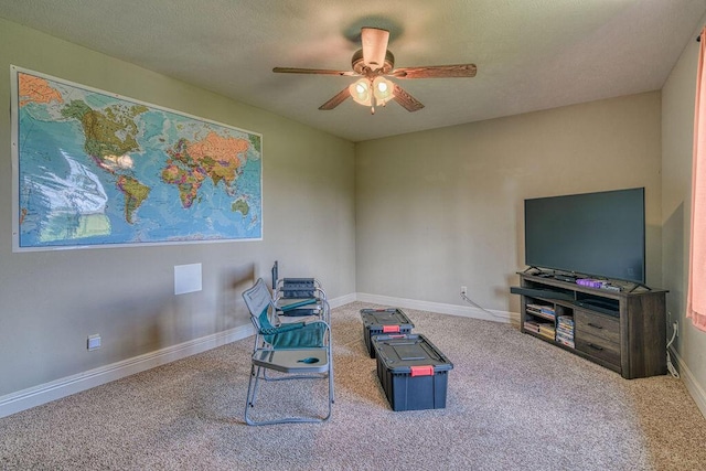 living area featuring carpet, ceiling fan, and baseboards