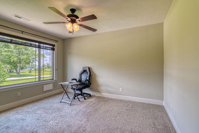 office area featuring light carpet, visible vents, baseboards, and ceiling fan