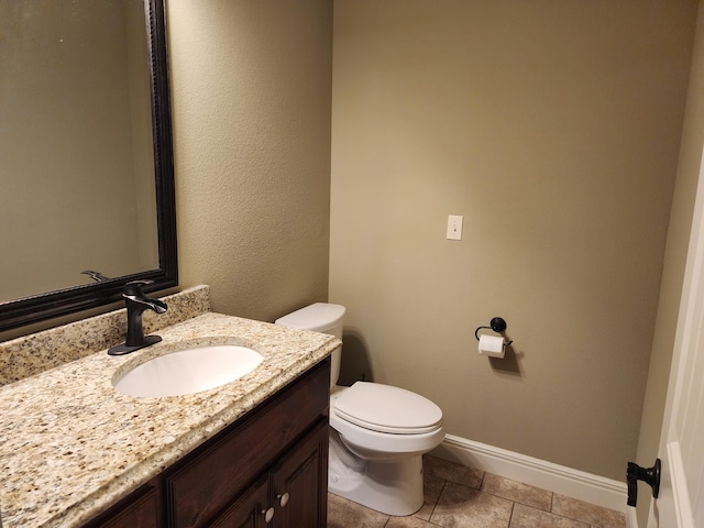 bathroom with toilet, tile patterned flooring, baseboards, and vanity