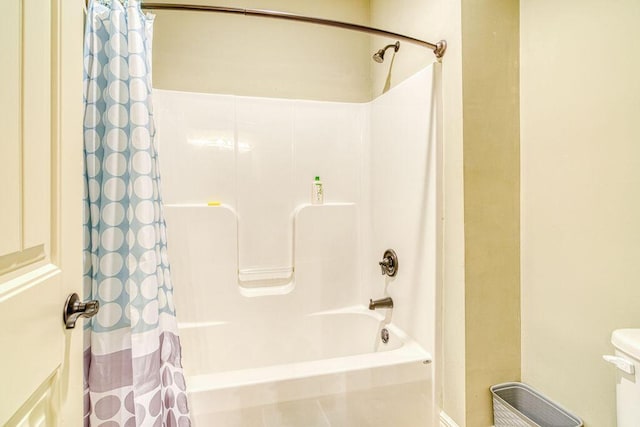 bathroom featuring shower / bathtub combination with curtain and toilet