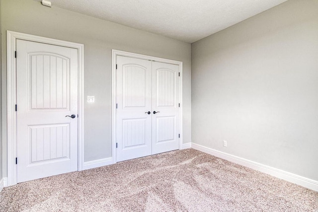 unfurnished bedroom with a closet, carpet flooring, and baseboards