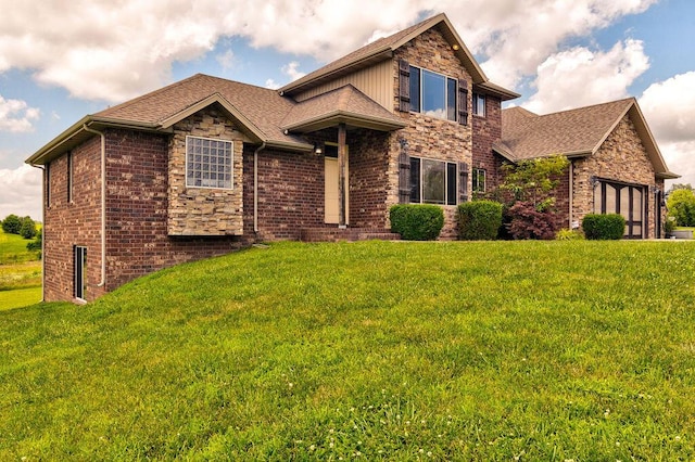 view of front of property featuring stone siding, a front lawn, roof with shingles, and brick siding