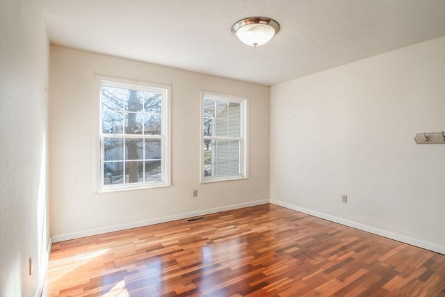 unfurnished room with baseboards, visible vents, and light wood finished floors