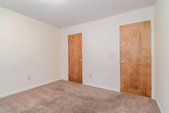 empty room featuring carpet floors and baseboards