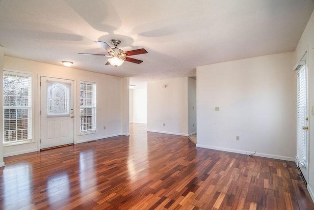 empty room with dark wood-type flooring, baseboards, and a ceiling fan