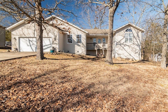 rear view of property featuring driveway, covered porch, and an attached garage