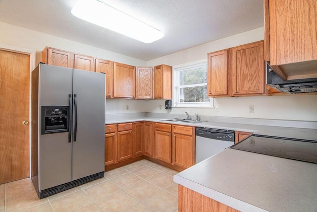 kitchen with a sink, stainless steel appliances, light tile patterned floors, and light countertops