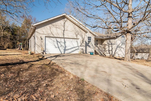 view of side of home with an attached garage and driveway