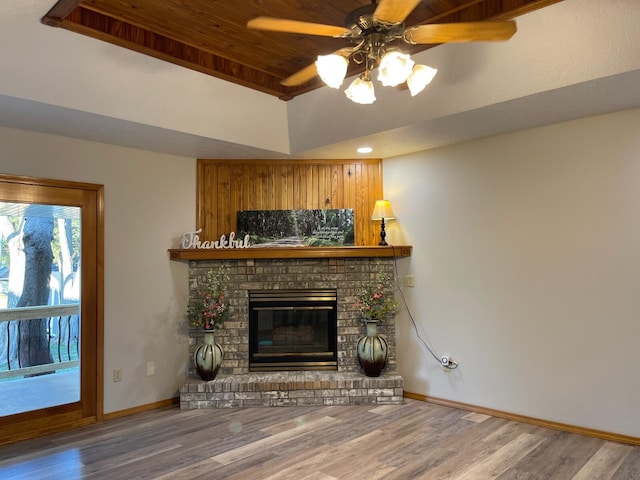 unfurnished living room with ceiling fan, a fireplace, baseboards, and wood finished floors