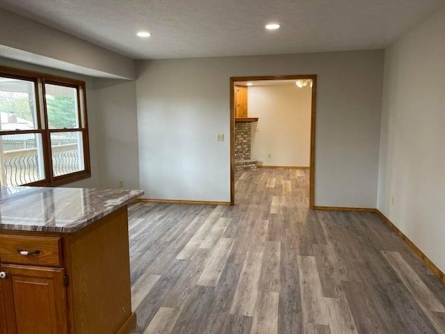 interior space featuring a textured ceiling, light wood finished floors, recessed lighting, and baseboards