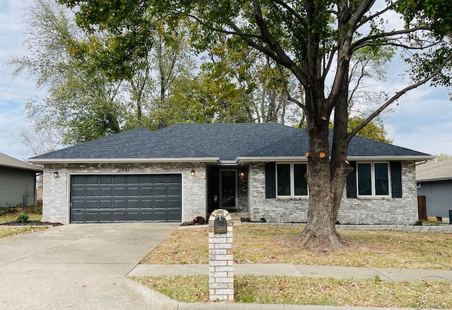 ranch-style house featuring a garage, roof with shingles, driveway, and brick siding