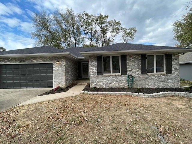 ranch-style home featuring concrete driveway, brick siding, an attached garage, and a shingled roof