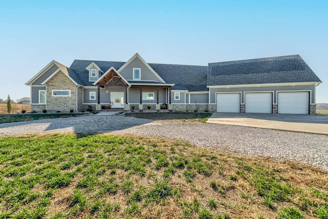 craftsman-style house featuring a garage, stone siding, and concrete driveway