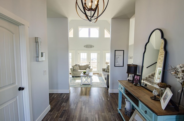 foyer with baseboards, dark wood-type flooring, a high ceiling, and a healthy amount of sunlight