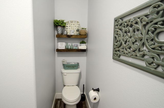 bathroom with toilet and baseboards