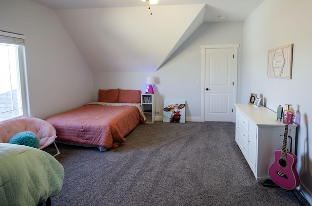 bedroom with dark carpet, vaulted ceiling, and baseboards