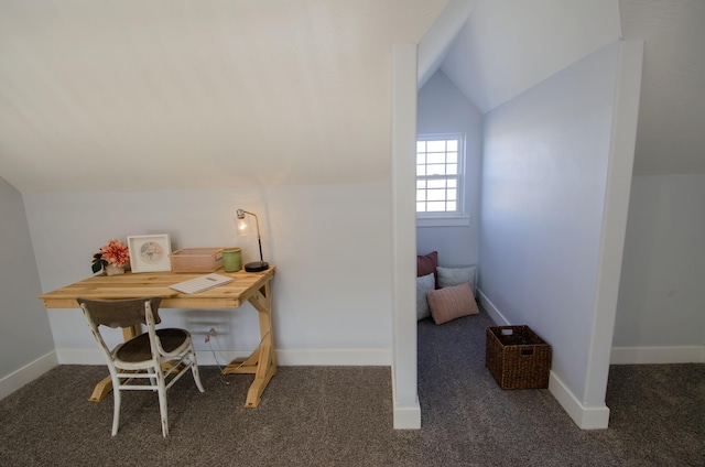 office area with vaulted ceiling, dark colored carpet, and baseboards