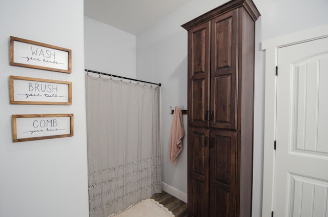 bathroom with wood finished floors and baseboards